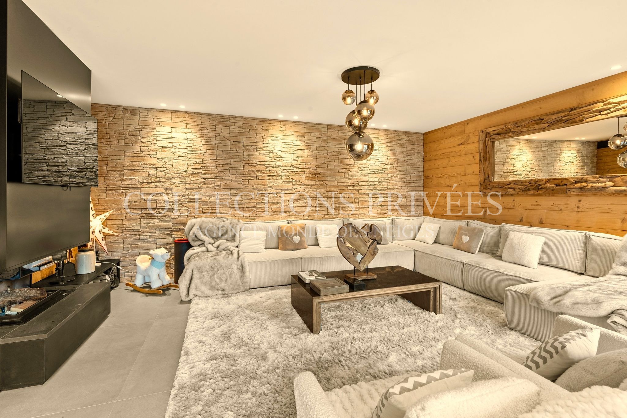 Espace séjour chalet prestige Auron mur pierre canapé