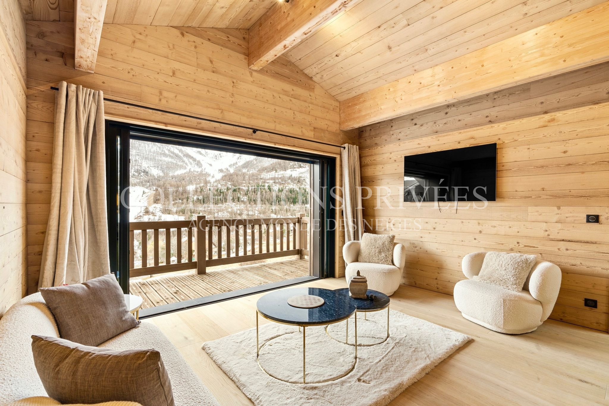 Salon cosy chalet Auron baie vitrée vue pistes ski